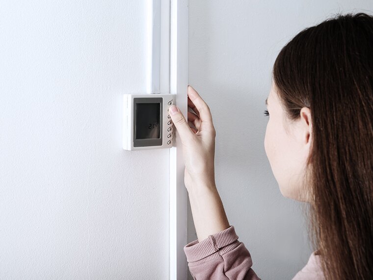 View over the shoulder of a woman operating the HVAC controller