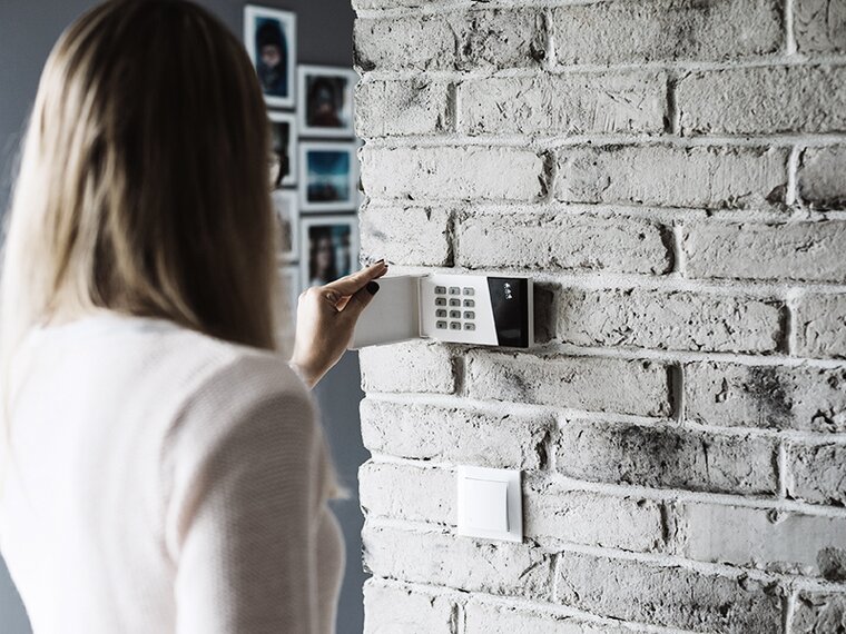 Looking over the shoulder of a woman entering the security codes